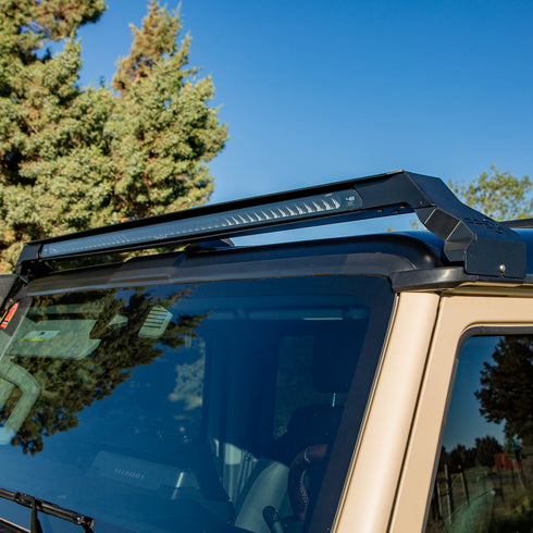 Low profile LED bar on an Ineos Grenadier with trees and blue sky in the background