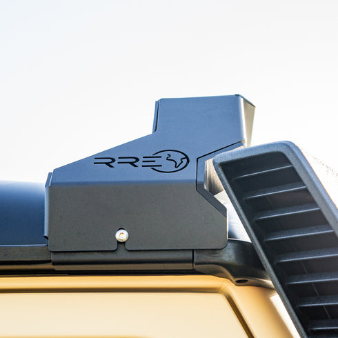 Close-up of a Low Profile LED Lite bar mount on the Roof of an Inoes Grenadier, showing the detail of the cutout to allow for the snorkel to be fitted together with the RRE logo on a Sky background