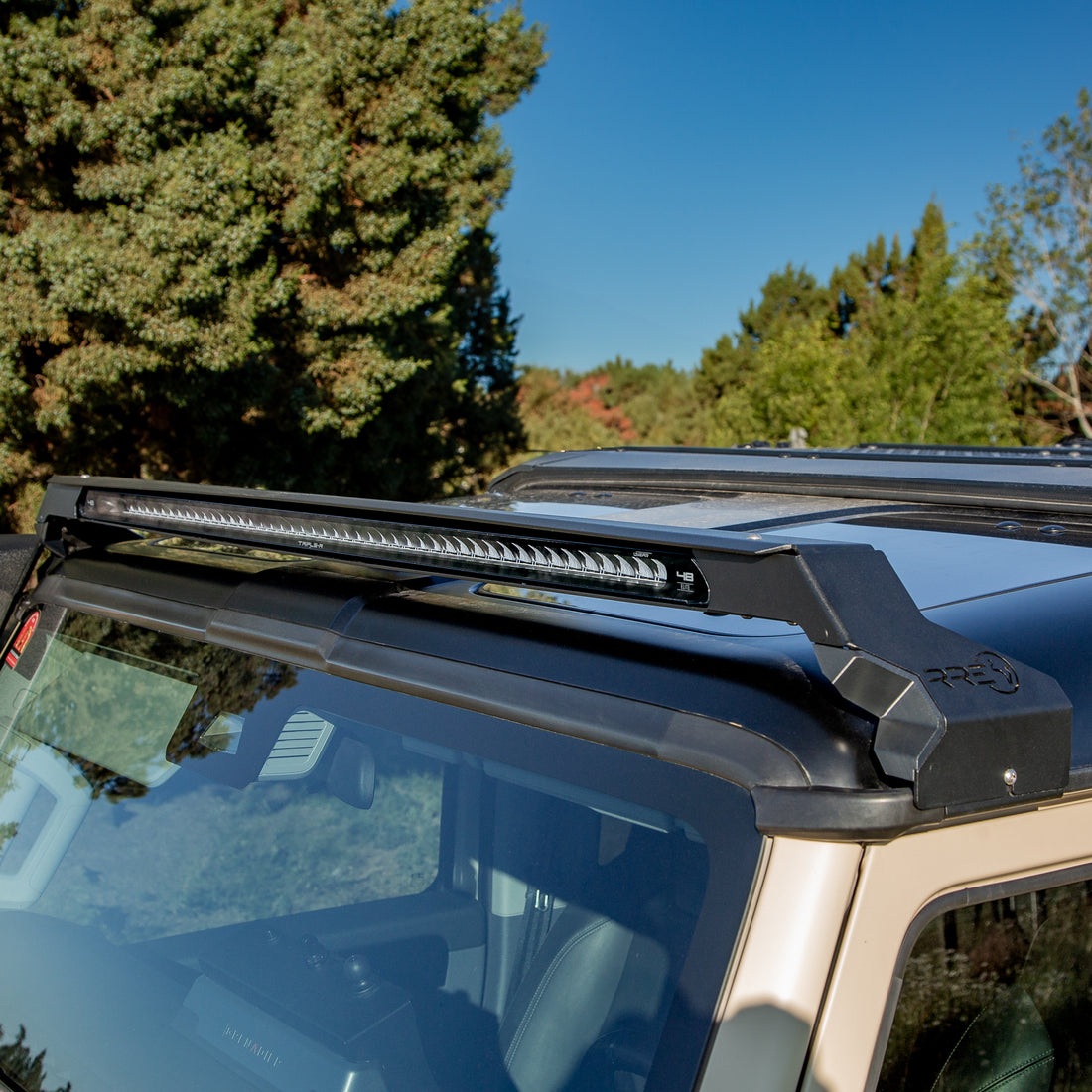Low profile LED bar on an Ineos Grenadier with trees and blue sky in the background