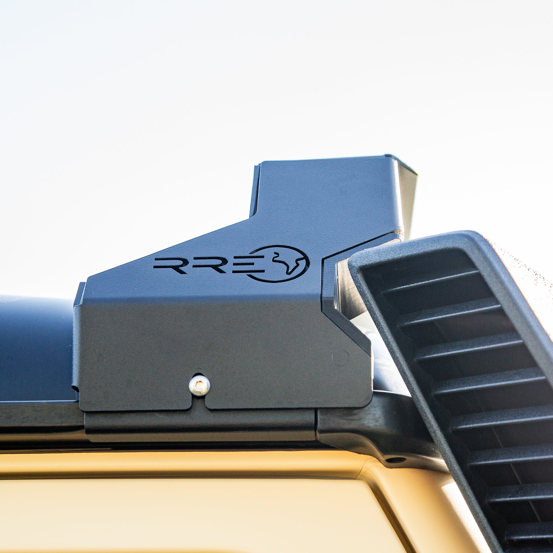 Close-up of a Low Profile LED Lite bar mount on the Roof of an Inoes Grenadier, showing the detail of the cutout to allow for the snorkel to be fitted together with the RRE logo on a Sky background
