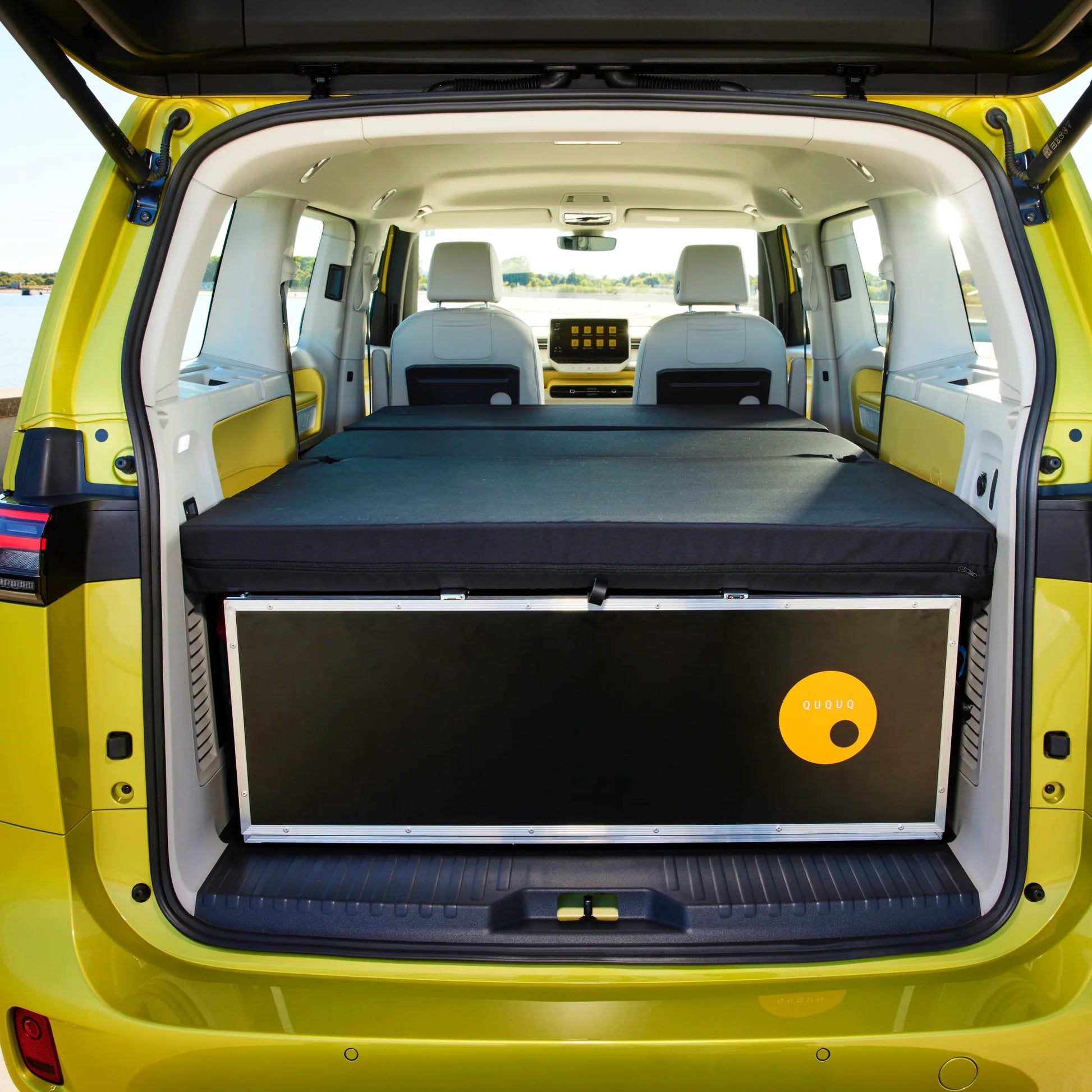 Ququq BusBox-4 modular camper box installed in a VW ID. Buzz, featuring a slide-out kitchen and integrated fold-out bed.