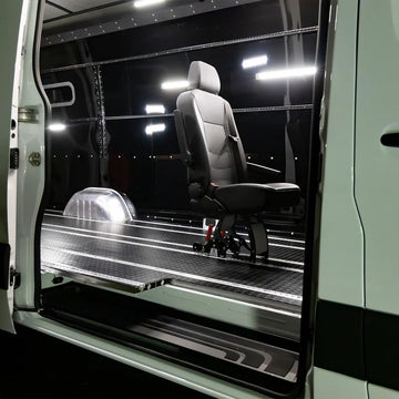 Modular aluminum SmartFloor track system installed in a Mercedes-Benz Sprinter for FMVSS-compliant seating and furniture.