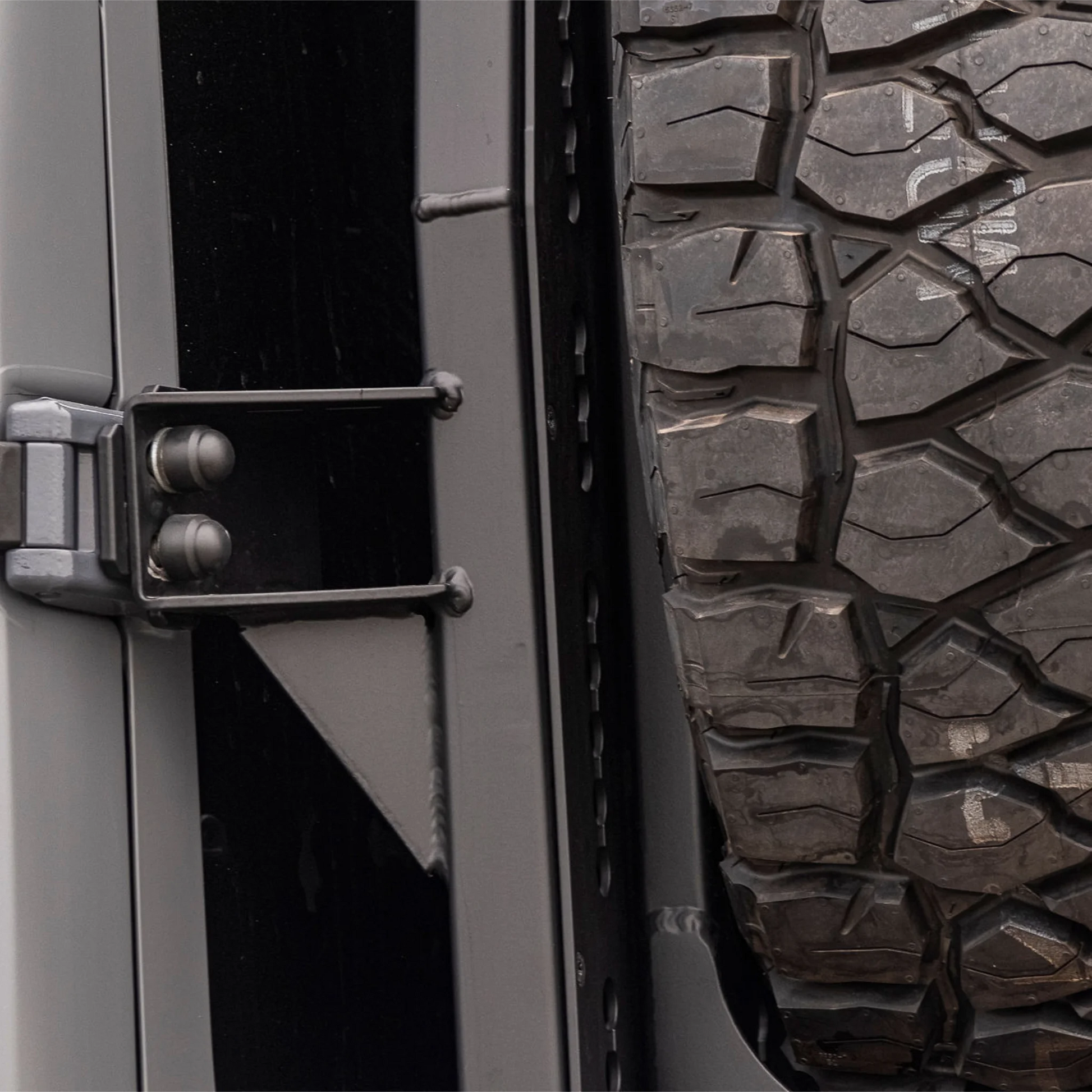 X-Bull aluminum cargo carrier mounted to a Sprinter rear door, holding a full-size spare tire 