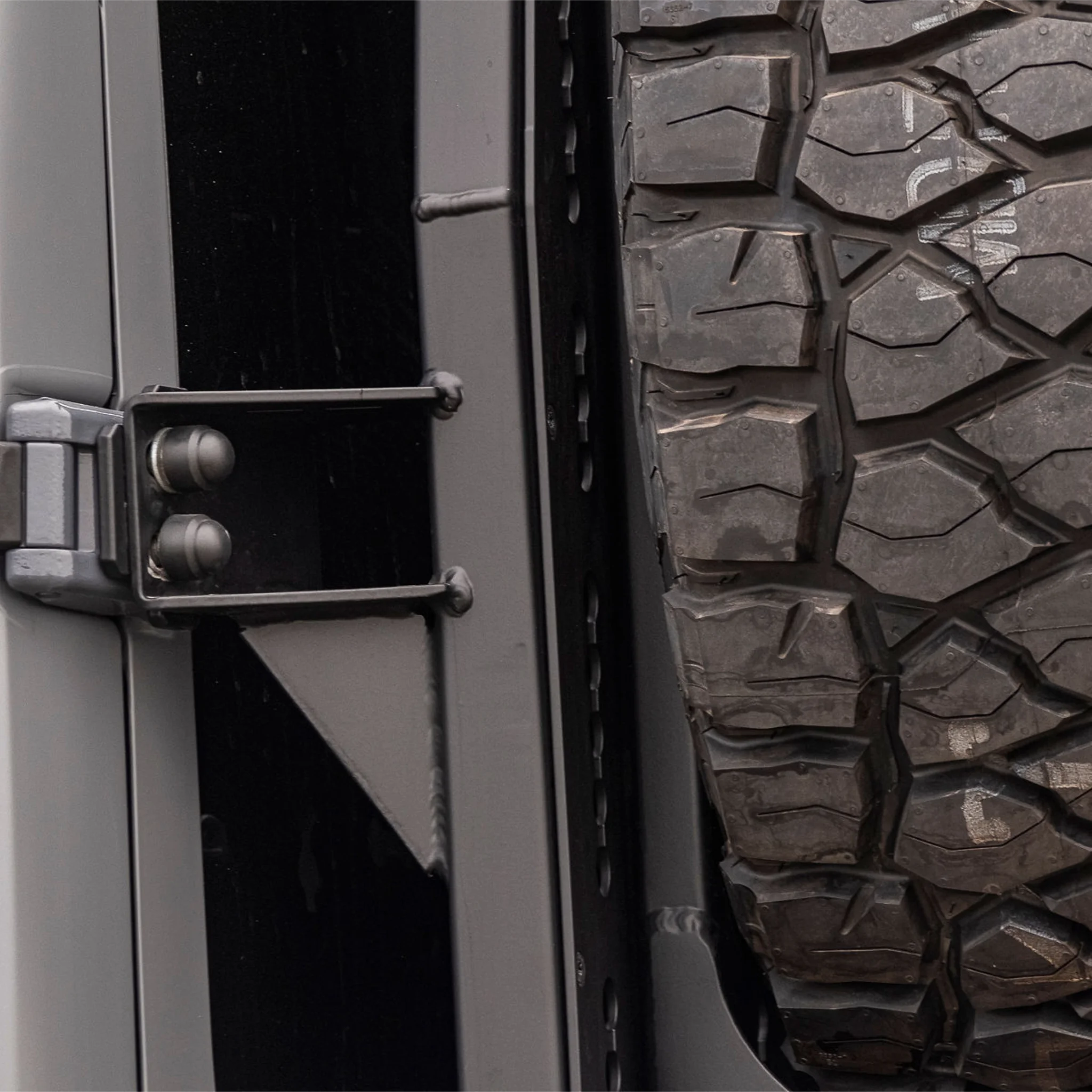 X-Bull aluminum cargo carrier mounted to a Sprinter rear door, holding a full-size spare tire 
